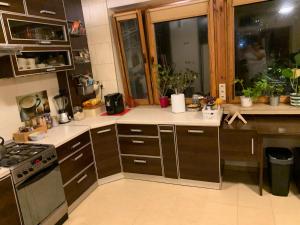 kuchnia z brązowymi szafkami i kuchenką w obiekcie Pokój w Wilanowie w Warszawie