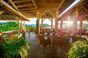 - un restaurant avec des tables et des chaises sur du parquet dans l'établissement Escape at Nonsuch Bay Antigua - All Inclusive - Adults Only, à Gaynors