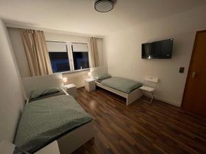 um quarto com 2 camas e uma televisão de ecrã plano em City Apartment Lux Bremen em Bremen