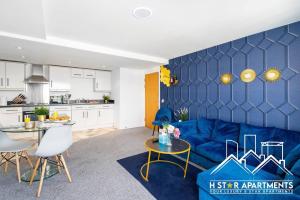 a living room with a blue couch and a kitchen at City Living Made Easy: 2BR Apartment in Birmingham in Birmingham