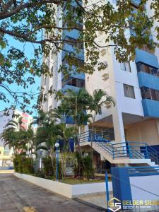 un bâtiment avec des escaliers bleus et des palmiers en face de celui-ci dans l'établissement CTC Torre B, Centro, à Caldas Novas