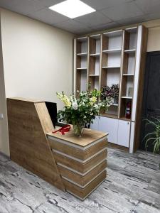 Pyunic Hotel في يريفان: مكتب صغير مع مكتب مع إناء من الزهور