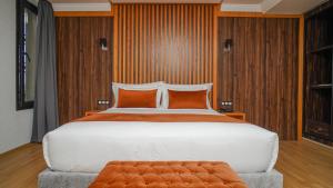 a bedroom with a large white bed with orange pillows at Razane Hôtel in Kenitra