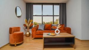 sala de estar con sofá naranja y silla en Razane Hôtel en Kenitra