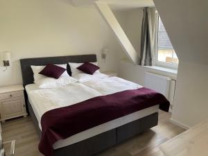 1 dormitorio con 1 cama grande con sábanas moradas y blancas en Seaside-Amrum-12, en Norddorf
