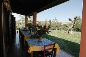 una fila di tavoli con fiori su un patio di Agriturismo Pian dei Pini a Montiano