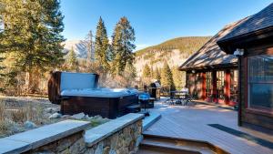 a hot tub on a deck next to a cabin at Breckenberg Haus in Breckenridge