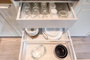 a drawer in a refrigerator with dishes and a washing machine at Primorski Residence Apartment in Varna City