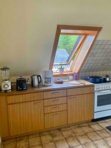 a kitchen with a counter top with a window at Gartenblick-Oase: Obergeschosswohnung in Hamburg in Hamburg