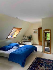 a bedroom with a bed with blue pillows and a window at Gartenblick-Oase: Obergeschosswohnung in Hamburg in Hamburg