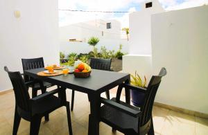 a black table and chairs with a bowl of fruit on it at Casa Tabaiba in Tías