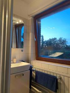 a bathroom with a sink and a window at Gartenblick-Oase: Obergeschosswohnung in Hamburg in Hamburg