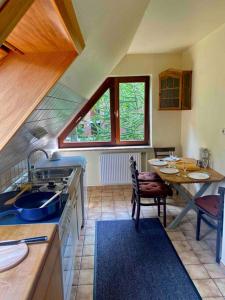 a kitchen with a sink and a table with a dining room at Gartenblick-Oase: Obergeschosswohnung in Hamburg in Hamburg
