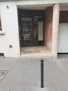 een gebouw met een deur met een paal ervoor bij Superbe Studio Paris Gambetta in Parijs