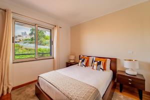a bedroom with a bed and a large window at Garajau Ocean Garden View in Caniço