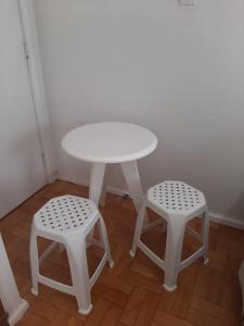 uma mesa branca e dois bancos num quarto em Quartos Aconchegantes prox Pelourinho, Metrô e Arena F Nova em Salvador