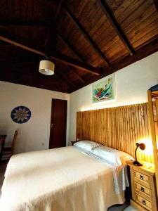 a bedroom with a large bed and a wooden ceiling at Long Life Campeche-Pousada in Florianópolis