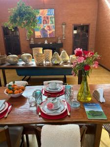 una mesa de madera con platos de comida y flores. en Go Organic Club - Santo Antônio do Pinhal SP, Brasil, en Santo Antônio do Pinhal