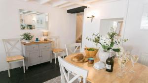 ein Esszimmer mit einem Holztisch mit Blumen darauf in der Unterkunft Gower Cottage in Beaumaris