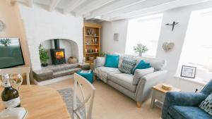 - un salon avec un canapé et une cheminée dans l'établissement Gower Cottage, à Beaumaris