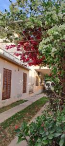 una casa con flores rojas a un lado. en Ayres de Catamarca en San Fernando del Valle de Catamarca
