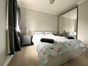 1 dormitorio con cama y espejo grande en Cheerful two-bedroom townhouse near Leeds and York en Leeds