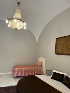 een slaapkamer met een bed en een kroonluchter bij B&B Carlo di Borbone in Caserta