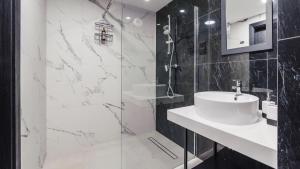 ein weißes Badezimmer mit Waschbecken und Dusche in der Unterkunft Resort Solny w Kołobrzegu Apartament A031 in Kołobrzeg