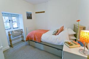 a bedroom with a bed and a table with a lamp at Melvin Cottage in Beaumaris
