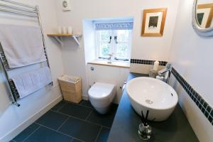 a bathroom with a white toilet and a sink at Melvin Cottage in Beaumaris +8 photos