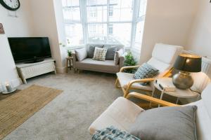 a living room with a couch and a tv at Hyfrydle in Beaumaris