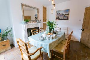 a dining room with a table and chairs and a fireplace at Hyfrydle in Beaumaris
