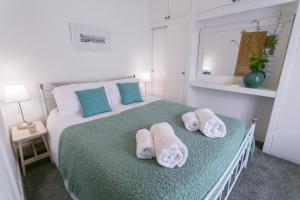 a bedroom with a bed with towels on it at Hyfrydle in Beaumaris