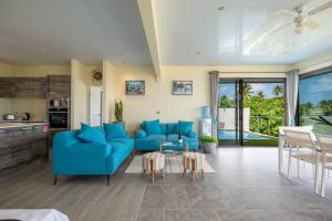 a living room with blue couches and a kitchen at Sunset Villa Bora in Bora Bora