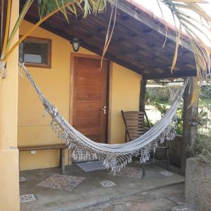a hammock on the porch of a house at Pousada Ceu e Serra in Carrancas