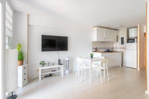 - une cuisine blanche avec une table et des chaises blanches dans l'établissement Apartamento Frente al Mar, à Benidorm