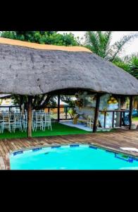 a hut with a swimming pool in front of it at Lasev Resort in Pretoria