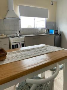 uma cozinha com uma mesa de madeira e uma bancada em Pueblo Nuevo 2 em Junín