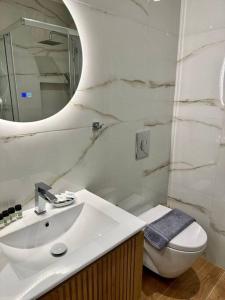a bathroom with a sink and a toilet and a mirror at Moschato Stylish Home 1 vipgreece in Piraeus