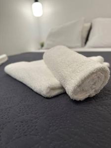 a white towel sitting on top of a bed at Moschato Stylish Home 1 vipgreece in Piraeus