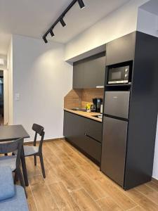 uma cozinha com um frigorífico preto e uma mesa em Moschato Stylish Home 1 vipgreece em Piraeus