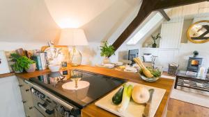 una cocina con fogones y una barra con frutas y verduras en Ty Fry Estate, en Pentraeth
