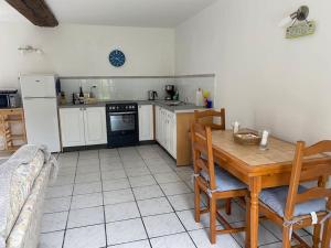 a kitchen with a wooden table and a kitchen with a refrigerator at La Detourbe holiday Gite in Beauvain