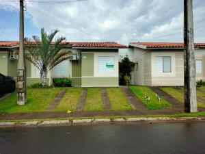 a house with a palm tree in front of it at casa flores in Foz do Iguaçu