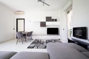a white living room with a couch and a table at Spazioso appartamento con terrazzo Navigli , Bocconi IULM NABA in Milan