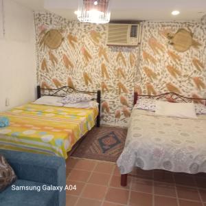 a bedroom with two beds and a wall at Hostal ROLLED in Villavieja