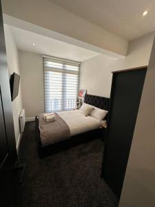 um pequeno quarto com uma cama e uma janela em Hamlet Court Apartment Flat 2A em Southend-on-Sea