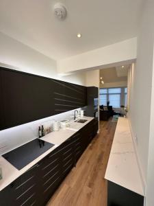 uma cozinha com armários pretos e bancadas brancas em Hamlet Court Apartment Flat 2A em Southend-on-Sea