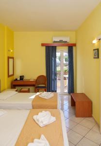 a hotel room with two beds with towels on them at Dedalos Beach Hotel in Sfakaki