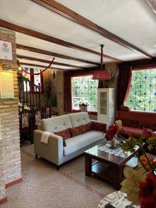 a living room with a couch and a table at Casa Rural Ermita Santa Maria de la Sierra in Arroyo Frio